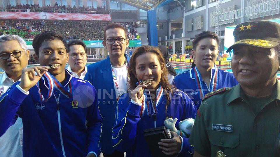 Raina Saumi Grahana (tengah) berpose dengan medali emas PON 2016 (14/09/16). - INDOSPORT